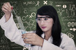 Beautiful scientist analysing liquid at workplace
