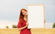 Redhead girl with blackboard at wheat field