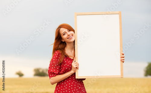 Photo: Redhead girl with blackboard at wheat field Redhead girl with blackboard at wheat field