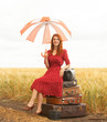 Redhead girl with suitcases at outdoor