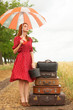 Redhead girl with suitcases at outdoor