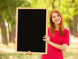 Redhead girl with blackboard at outdoor