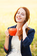 Redhead girl with orange cup at outdoor