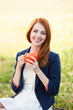 Redhead girl with orange cup at outdoor