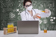 Beautiful female scientist pour liquid with written chalkboard
