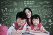 Beautiful teacher see children writing in class