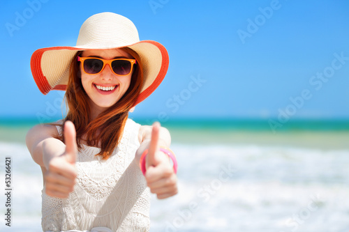 Photo: Redhead girl on the beach in spring time. Redhead girl on the beach in spring time.