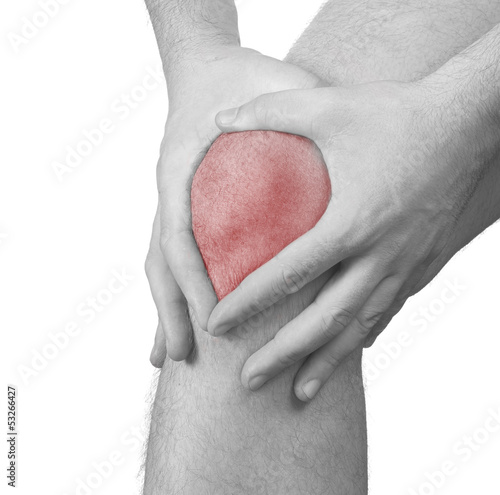 Photo: Acute pain in a man knee. Male holding hand to spot of knee-ach Acute pain in a man knee. Male holding hand to spot of knee-ach