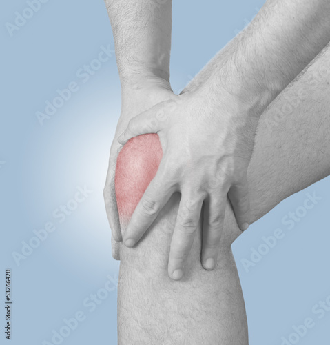 Photo: Acute pain in a man knee. Male holding hand to spot of knee-ach Acute pain in a man knee. Male holding hand to spot of knee-ach
