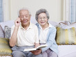 senior asian couple holding a book and smiling