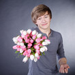 Junger Mann überreicht Blumen