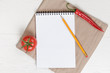 recipe notepad on wooden table with pepper and tomato