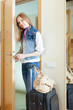 Photo: woman with luggage loocking door woman with luggage loocking door