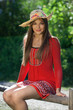 Beautiful girl in a red dress and a hat