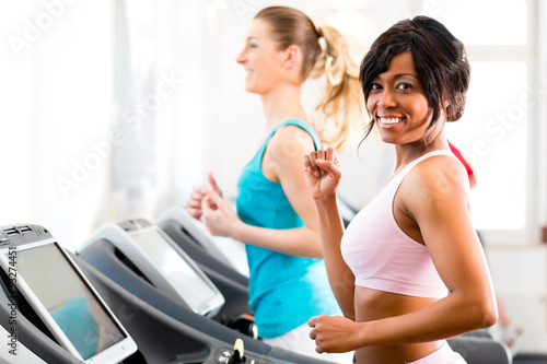 Photo: People in sport gym on treadmill running People in sport gym on treadmill running