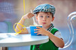 Cute little boy eating ice cream at indoor cafe
