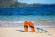 Slippers, mask and snorkel on sand beach