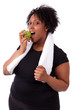 Photo: Overweight young black woman eating an apple - African people Overweight young black woman eating an apple - African people