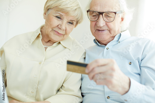 Photo: Senior couple with card Senior couple with card