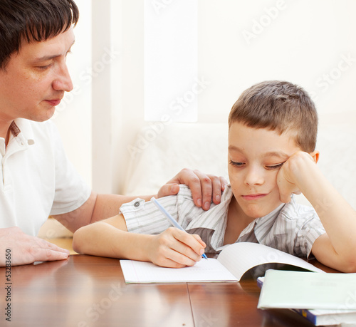 Photo: Father helping son do homework Father helping son do homework