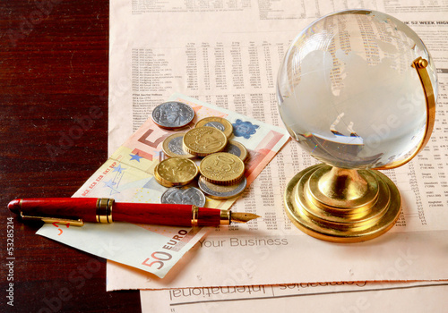 Photo: Globe and money euro isolation on wood background Globe and money euro isolation on wood background