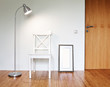 Wooden Chair with floor lamp to face a blank white wall