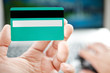 Man holding credit card in hand and entering security code using