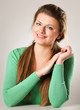 A young woman sitting isolated on grey background