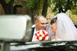 Happy bride with groom smiling inside car