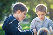 Photo: Young brothers playing on a sunny day in a park. Young brothers playing on a sunny day in a park.