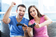 Excited couple playing video games on the sofa