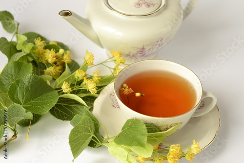 Photo: Cup of tea with linden flowers on a white background Cup of tea with linden flowers on a white background