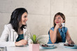 Two young female friends gossiping in a bar.