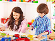 Family with child playing bricks.