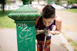 beautiful hipster short hair woman drinking water in the park