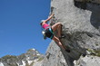 Frau klettert am Fels