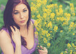 girl sitting in a summer field with flowers