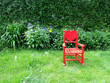 Red Rocking Chair in Garden with Flowers