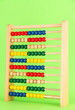 Bright wooden toy abacus, on green background