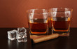 Glasses of whiskey and cigar on brown background