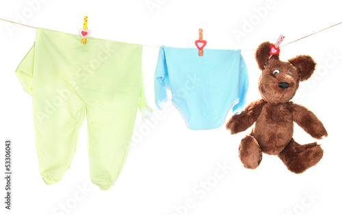 Photo: Baby clothes hanging on clothesline, isolated on white Baby clothes hanging on clothesline, isolated on white