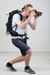 Handsome photographer with camera, on gray background
