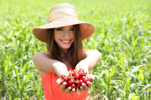 Photo: Portrait of beautiful young woman with berries in the field Portrait of beautiful young woman with berries in the field