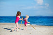 Two sisters playing on a sandy beach