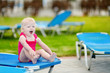 Adorable toddler girl sitting on a sunbed