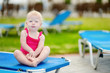 Adorable toddler girl sitting on a sunbed