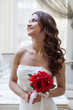 Photo: Portrait of happy bride posing with red bouquet Portrait of happy bride posing with red bouquet