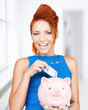 woman putting cash money into piggy bank