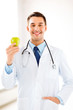 Photo: male doctor with green apple male doctor with green apple