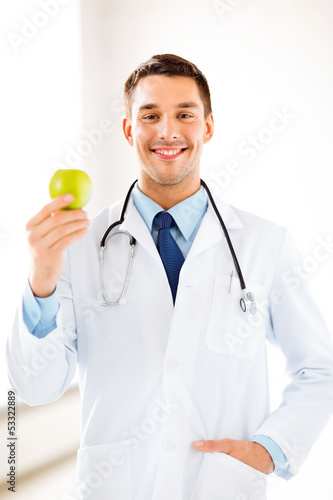 Photo: male doctor with green apple male doctor with green apple